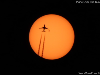 Plane over the Sun by worldtimezone