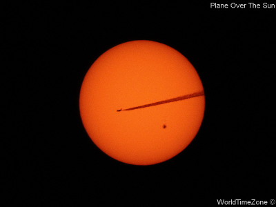 Plane over the Sun by worldtimezone